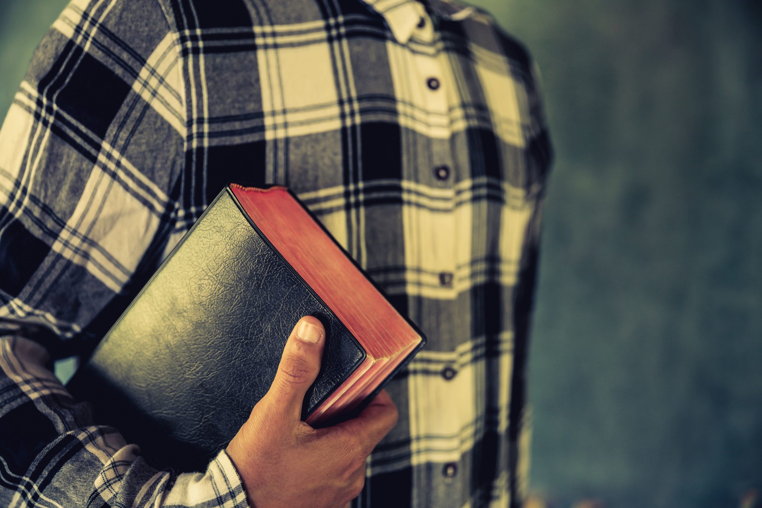 Jovem segurando bíblia nas mãos